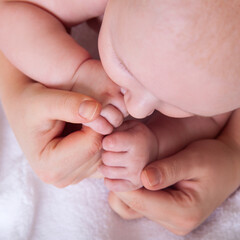 Cute baby hands holding mother's fingers.