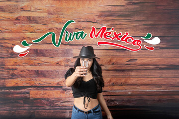 mexican woman showing shot of tequila with the text long live Mexico in Spanish. viva mexico. mexican independence day concept
