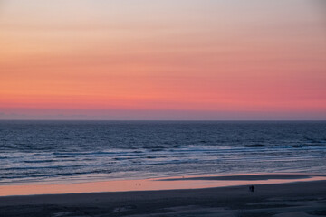 Fototapeta na wymiar Haystack rocks silhouette against colorful sunset evenings on the beach
