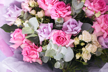 A large colorful bouquet of flowers. Large pink roses and eucalyptus leaves. On a light background, side view. The concept of the holiday. High quality photo