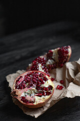 juicy red pomegranate on craft paper and wooden background