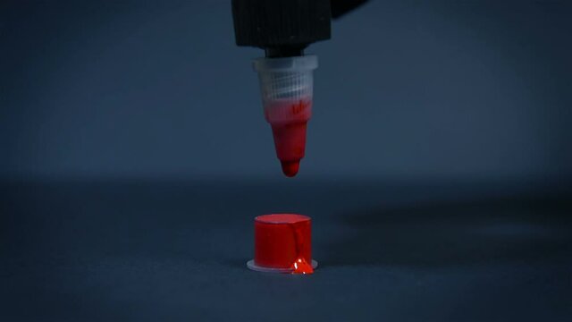 Tattoo Artist Pours Red Ink Into A Small Plastic Cup. Art And Design Concept. Close Up