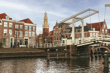 Fototapeta premium Cityscape of the center of the historic Dutch city of Haarlem, with the Gravesteen bridge over the Spaarne in the foreground and the tower of the Bakenesserkerk in the background.