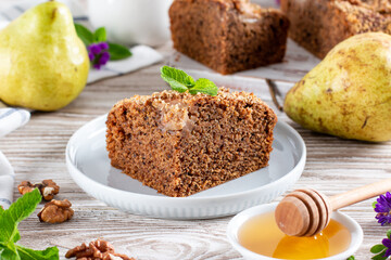 Piece of homemade chocolate cake with pears and chocolate on a wooden background