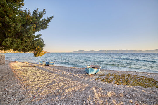 Blue fishing boat on an empty beach in Gradac, Croatia