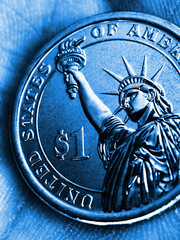 US coin lies on the palm. Blue tinted vertical illustration. Economy and finance. 1 one dollar coin close-up. The Statue of Liberty. Wages, manual labor and blue-collar workers. Macro