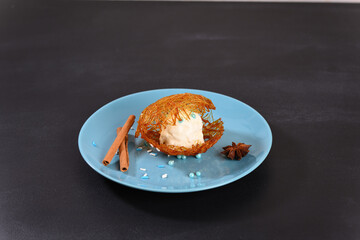 Ice cream in sugar caramel on a blue plate.