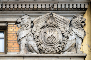 Coat of arms with two mythological winged lions on the facade of a historical red brick building in center of SPb., Russia.