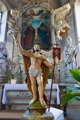 Poster Jesus Resurrection statue with the maltese cross flag inside the church in front of altar with painting of Saint Peter and Paul. © milkovasa