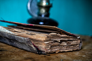 An old book standing in front of a kerosene lamp. stock photo.
