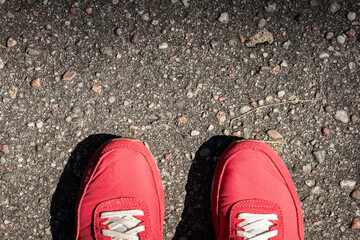 Czerwone sportowe buty na asfalcie. 