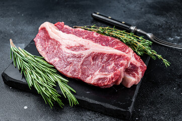 Raw Striploin steak or New York steak beef meat cut. Black background. Top view