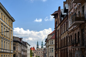 street with facades of historic tenement houses and church bell towers