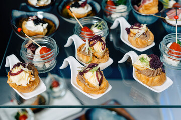 Gourmet tartlets with pate and shrimps. Beautiful layout, on glass shelves.