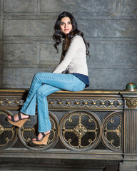 Fototapeta na wymiar A young pretty woman is sitting on a metal railing and relaxing..