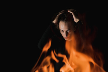 The view of an adult guy through the fire in complete darkness