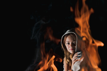 The view of a young girl through the fire in complete darkness