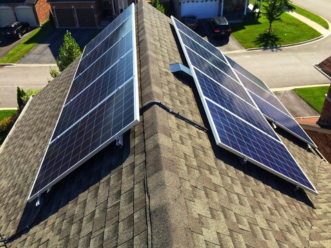 Side view at solar panels on residential roof in Ontario, Canada.Production of solar panels. Green energy concept.
