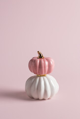 Two decorative glossy pumpkins standing vertically on top of each other on pink background. - 452064468