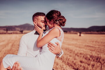a young married couple in a large field enjoys the sunset. Selective focus