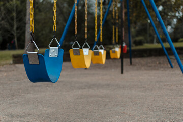 close-up, horizontal shot of colorful park swings