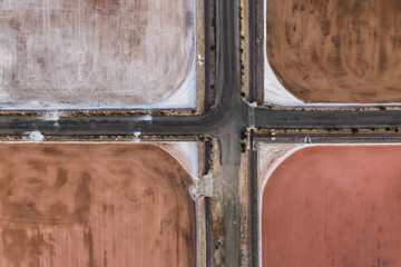 Aerial shot of crossroads at salt factory in Santa Pola, Alicante, Costa Blanca, Spain. Salty pink red lakes on mediterranean sea coast.