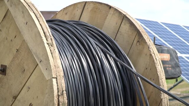 Construction site footage of a cable spool unwinding, solar power station