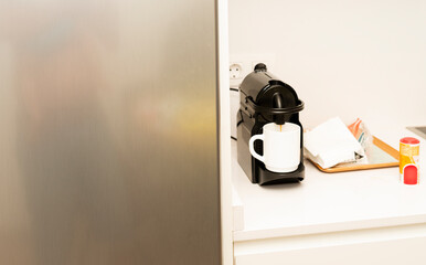 Coffee maker preparing a coffee in a white cup. Copy space.