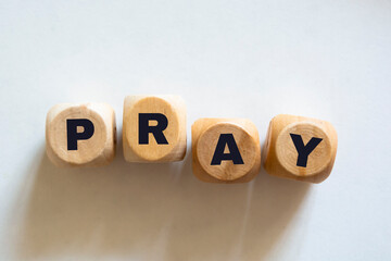 Pray word on wooden blocks. White background. Copy space