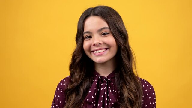 happy teen girl portrait with curly hair and smooth skin smiling yellow background, emotions