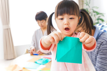 折り紙で遊ぶ子供と家族