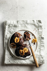 Zucchini brownie on a white plate on gray textured background