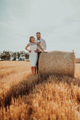 a young married couple in a large field enjoys the sunset. Selective focus