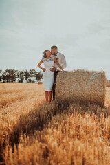 a young married couple in a large field enjoys the sunset. Selective focus