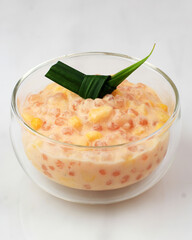 Indonesian Food : Bubur Jagung Mutiara, Indonesian Traditional Porridge on Wooden Table. Made of Corn, Pearl Sago, Coconut Milk, and Sugar. Popular in Javanese and Aceh