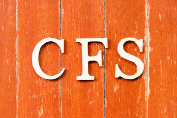 Alphabet letter in word CFS (Abbreviation of Container Freight Station, Certified fund specialist or Chronic fatigue syndrome) on old red color wood plate background