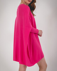 Beautiful caucasian girl in a sensual pink/fuchsia plain mini dress