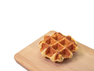 Round waffle, a close up of traditional homemade delicious crispy waffle cake dessert on wooden board isolated on white background.