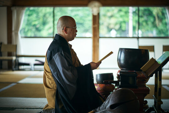朝のお勤めをする寺の住職