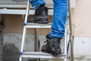 Wear safety shoes to ensure safety at work. construction workers wear safety shoes. concept. Construction workers work on the stairs