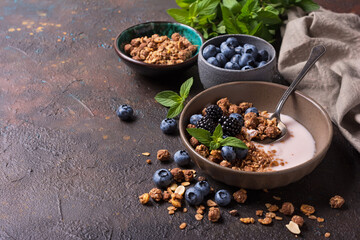 Bowl of healthy breakfast with granola, yogurt, fresh berries and mint