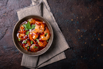 Tasty bright seafood. Bowl of shrimps in spicy asian red sauce