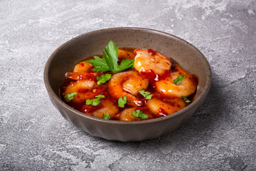 Tasty bright seafood. Bowl of shrimps in spicy asian red sauce