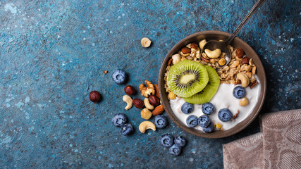 Fototapeta na wymiar Bowl of healthy breakfast with granola, yogurt, fresh fruits, berries and nuts