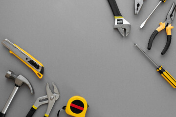 Flat lay composition with construction and home repair tools tools on grey background, space for...