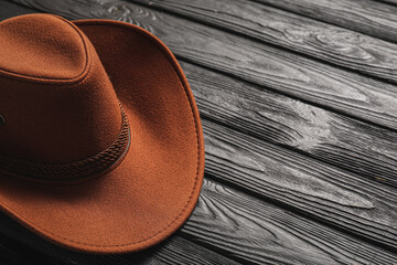 Stylish cowboy hat on dark wooden background, closeup