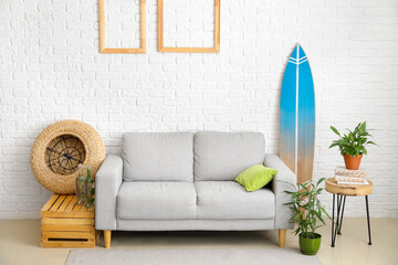 Obraz premium Interior of modern stylish room with surfboard, sofa and houseplants