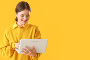 Young woman with laptop on color background