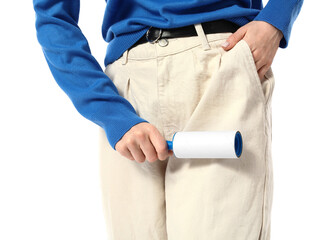 Young woman cleaning her pants with lint roller on white background