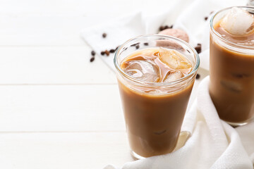 Glasses of tasty iced coffee on table